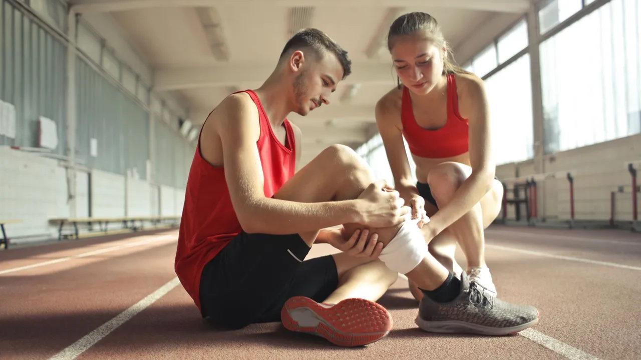 Coureur assis sur un banc, main posée sur son tibia douloureux, illustration médicale du sport